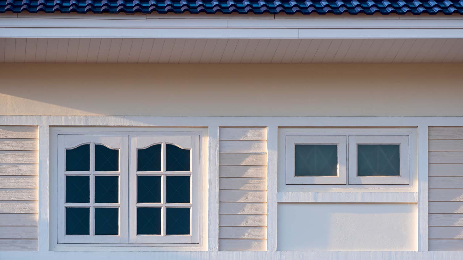 beige house with dark tinted windows