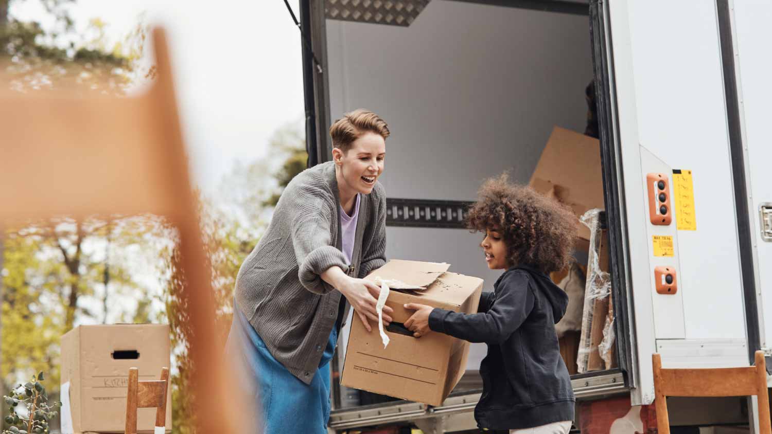 Boy helping mother in unloading cardboard box