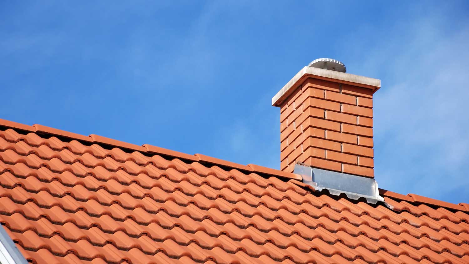 A brick chimney on a tiled roof