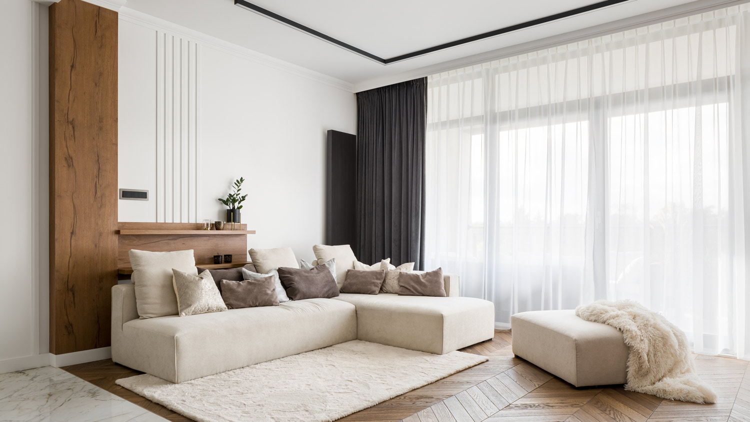 A bright living room with a tall windows and beautiful long curtains