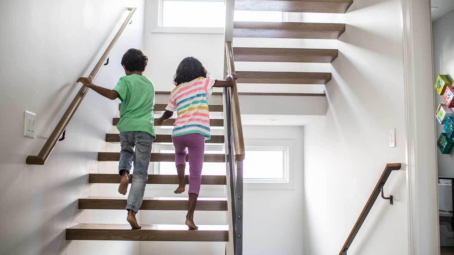 Siblings running upstairs at home