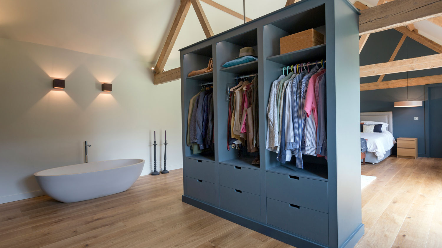 A closet and a bathtub in an open-space modern bedroom
