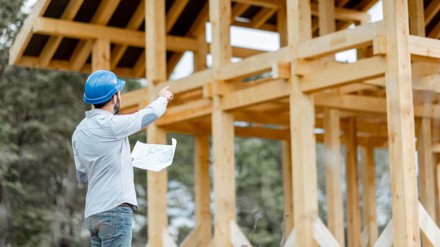 A contractor supervising the framing of a house