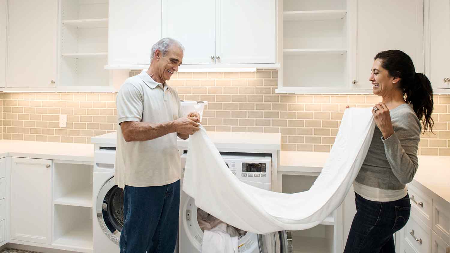 Couple folding clothes in the home laundry room