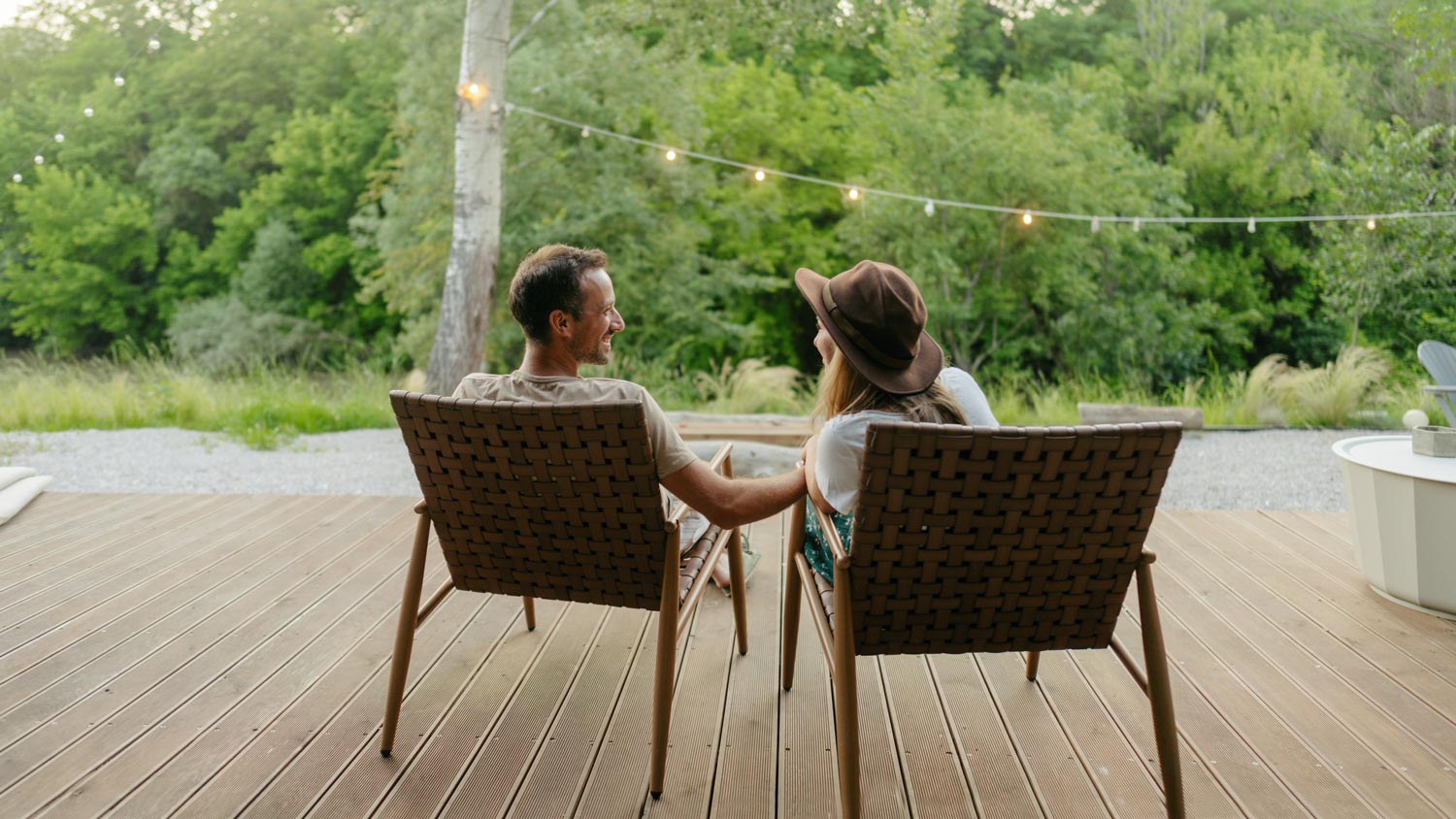 Couple sitting on deck talking.