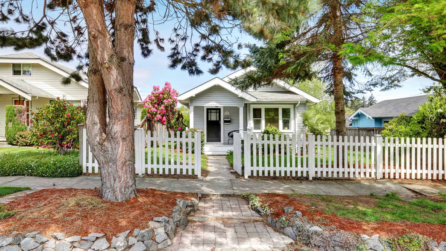 The exterior of a house with a white picket fence