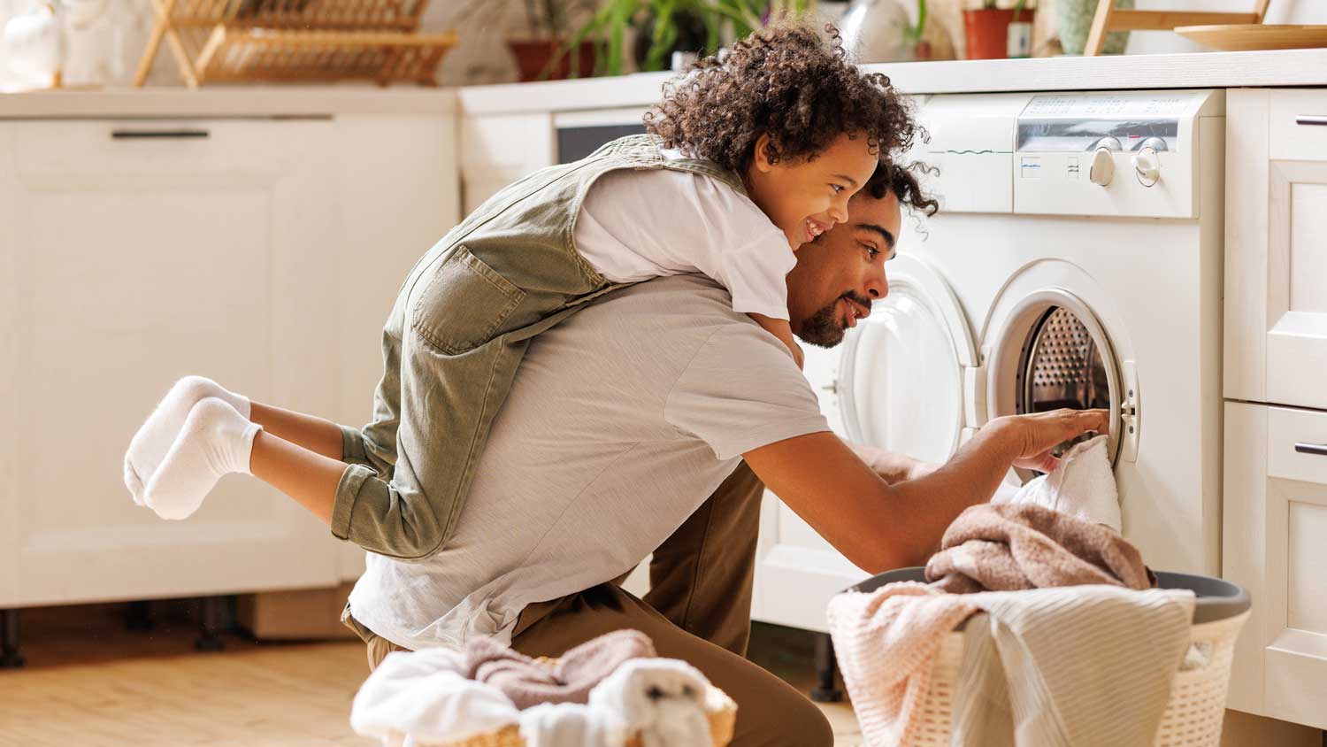A father with his son loading the washing machine
