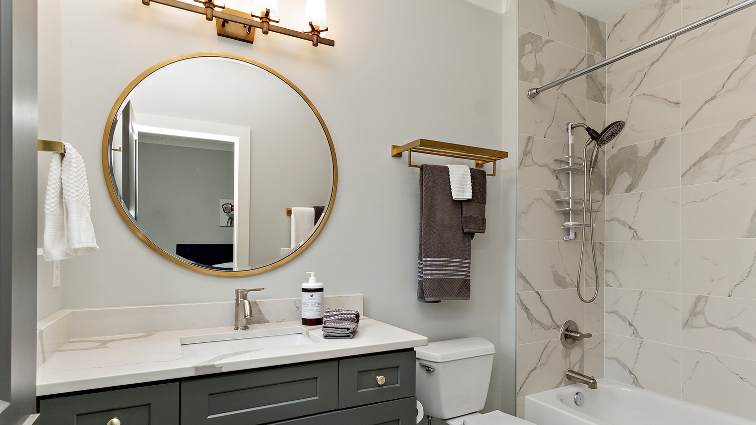 Gold round mirror in small bathroom