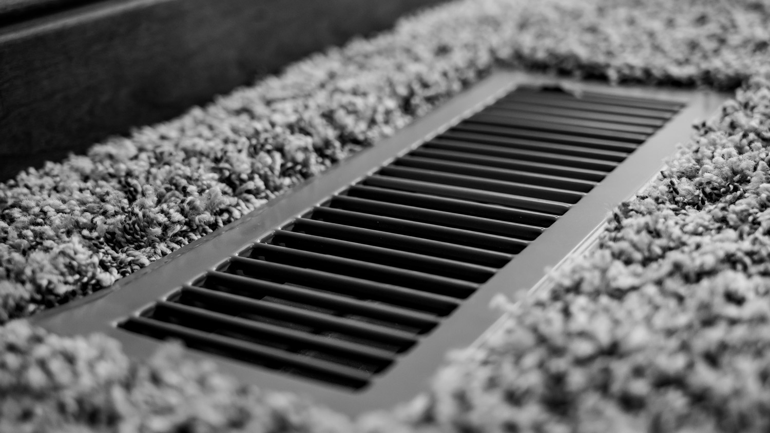 Focus on floor vent in room with carpet