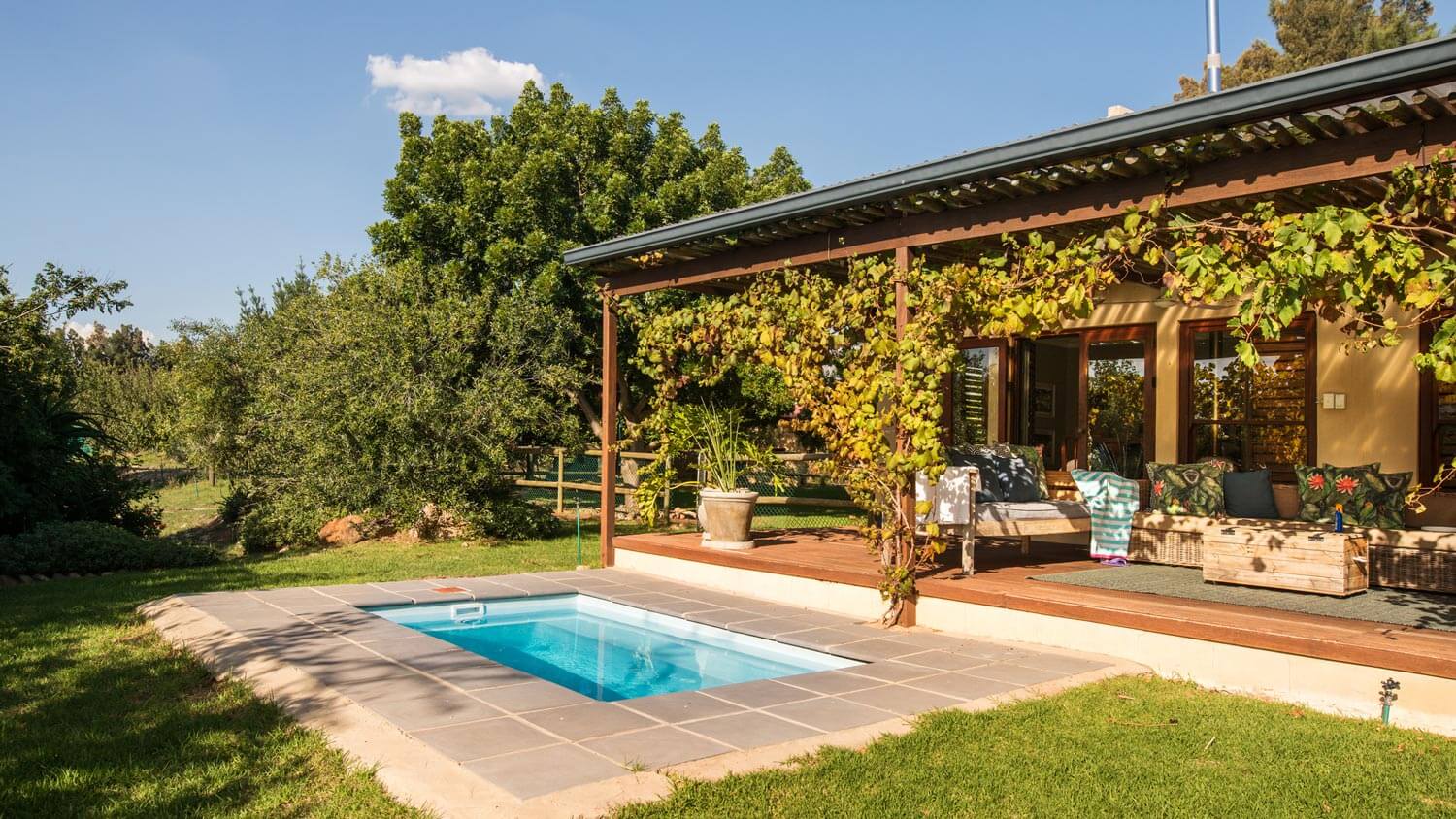 A guest house with a patio and a small pool