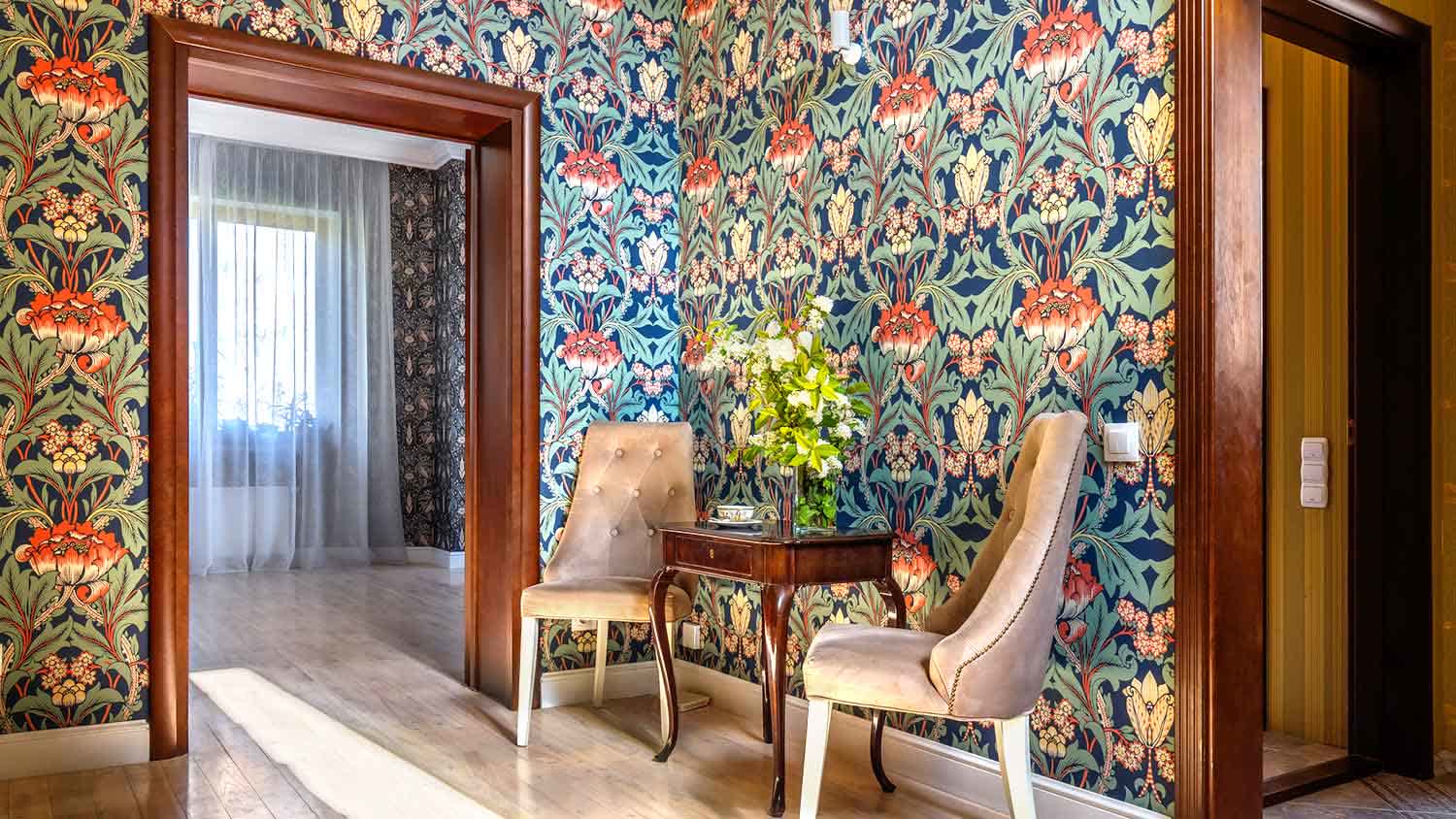 Coffee table and chairs in an entryway with floral wallpaper