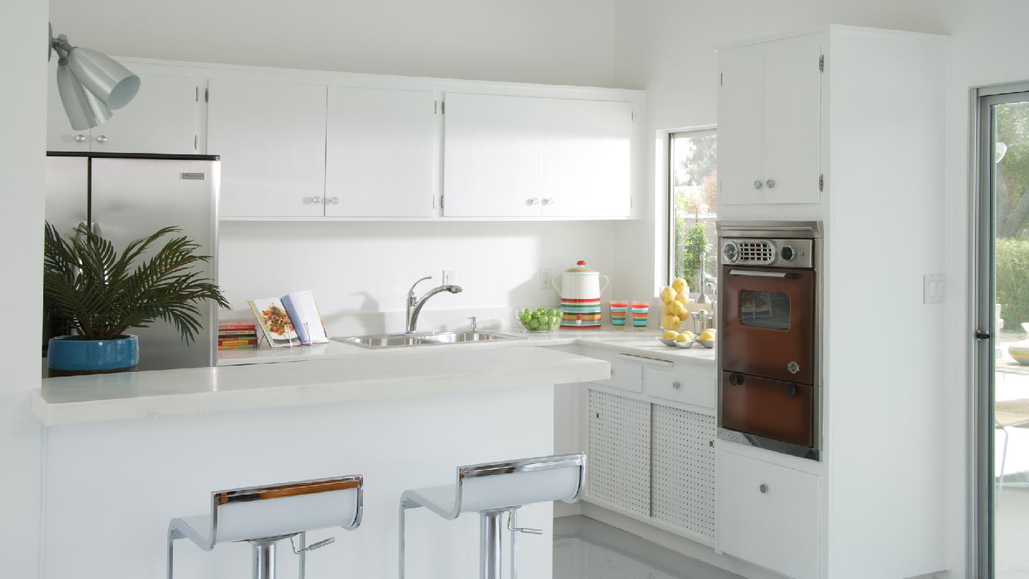 A kitchen with white cabinets and a vintage oven
