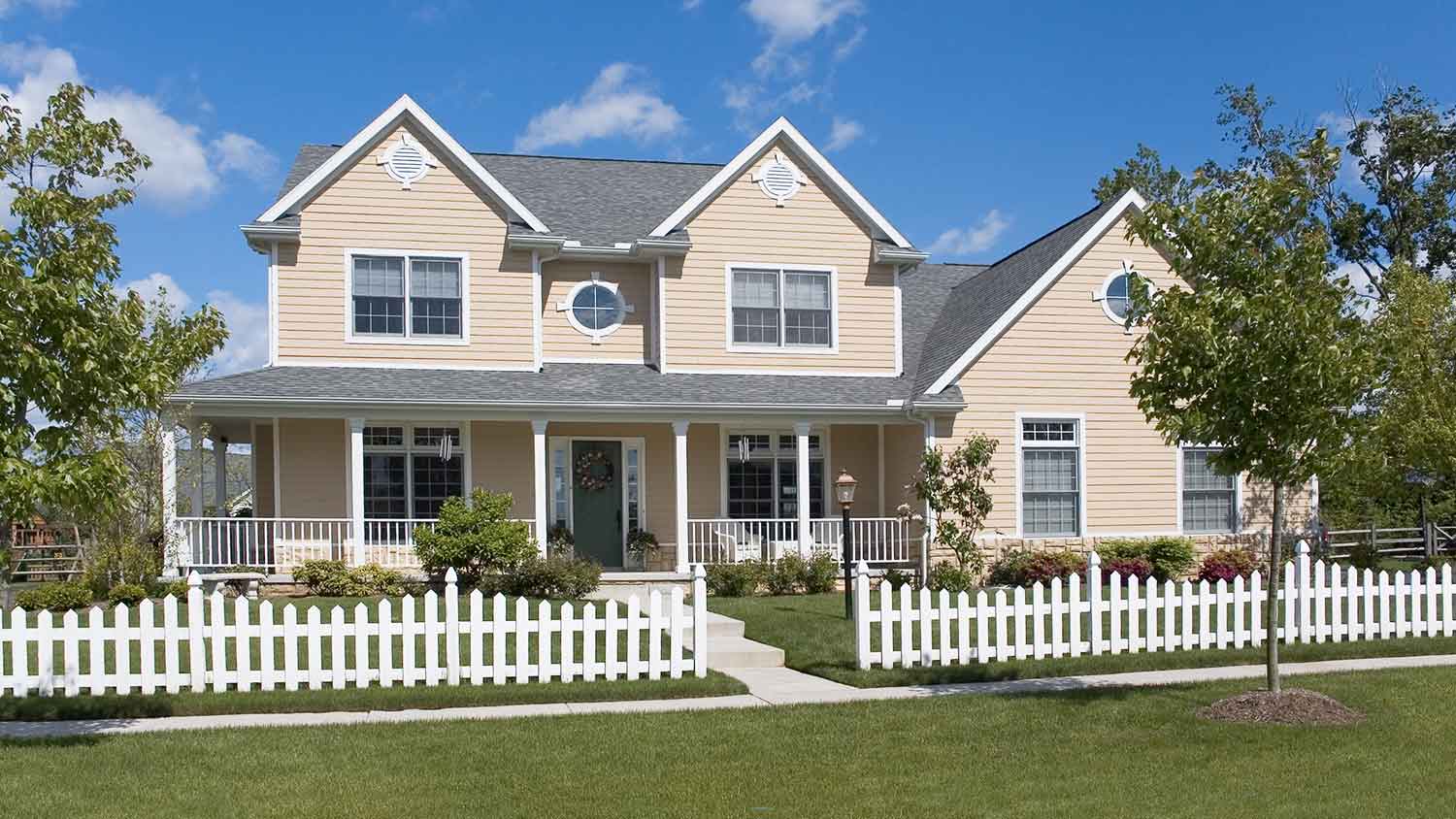 Large home surrounded by a white wooden fence