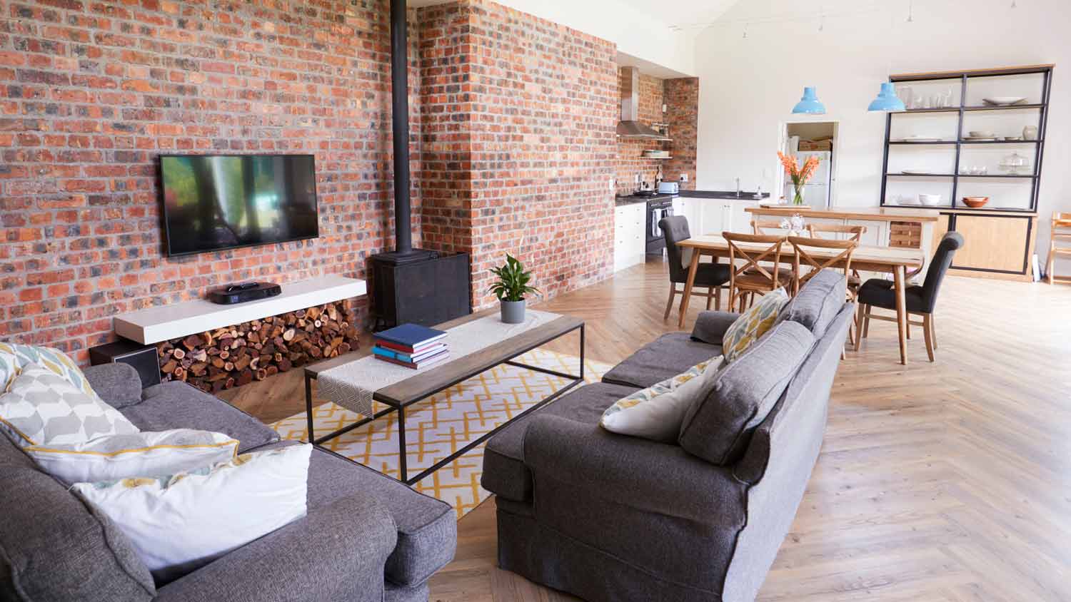 living room with tv mounted on brick wall