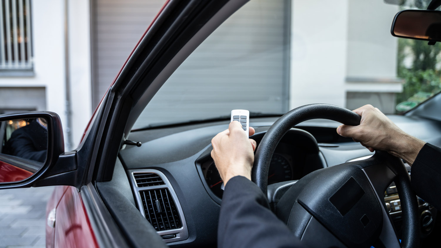 A man using a remote control to open her garage door