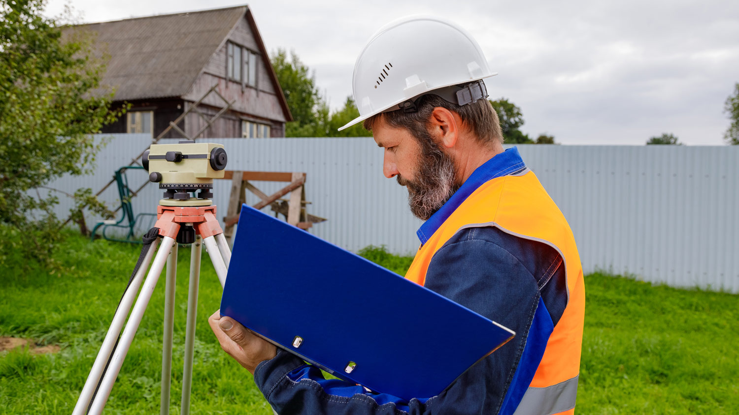 A civil engineer writes down the readings of the optical level