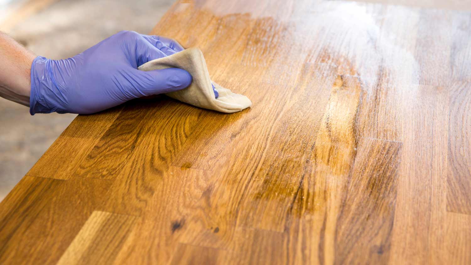 person oiling butcher block counter