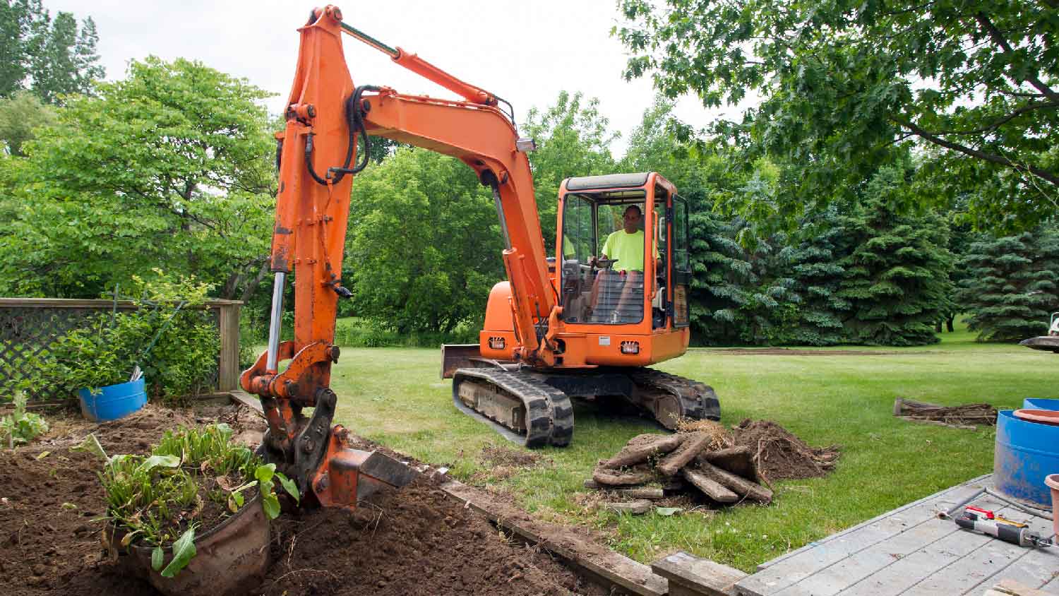A person regrading yard by excavating soil