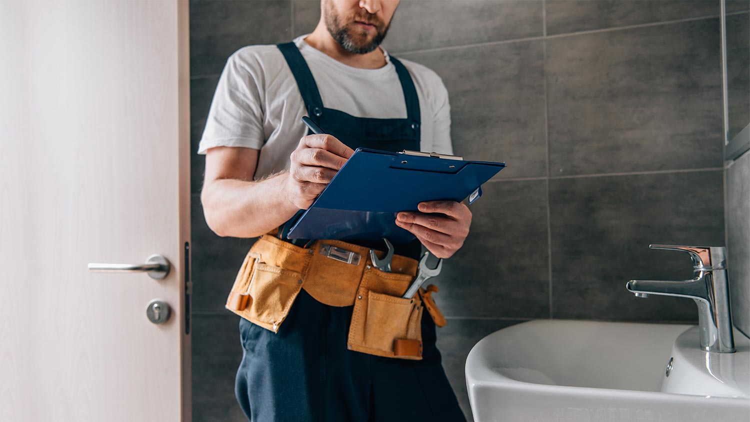 plumber assessing broken faucet 