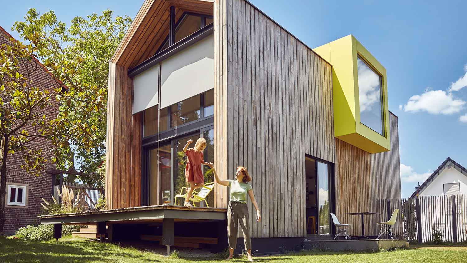 Mother and daughter outside of a modern sustainable house
