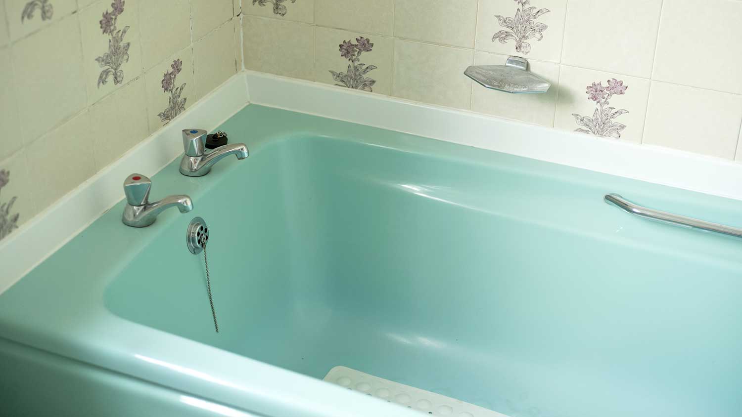 Turquoise fiberglass bathtub in a vintage bathroom 