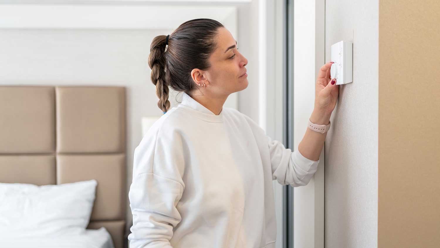 Woman adjusting temperature in the bedroom