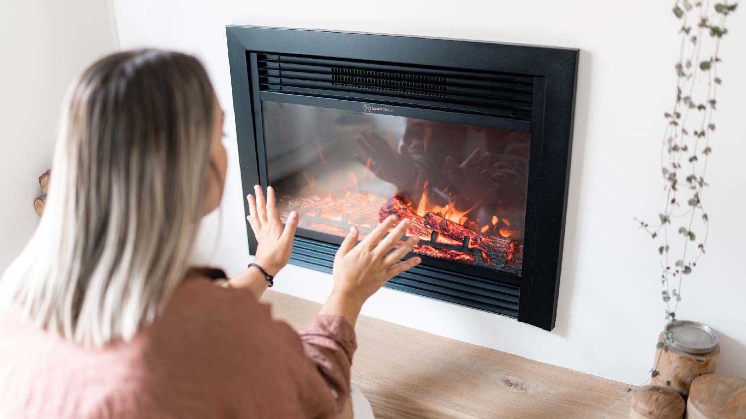 A woman in front of an electric fireplace