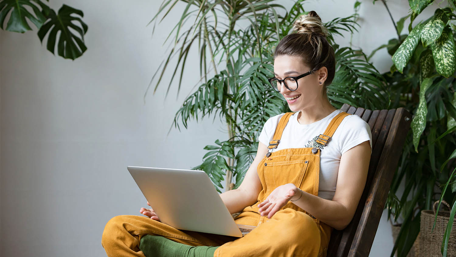 woman on laptop surrounded by plants