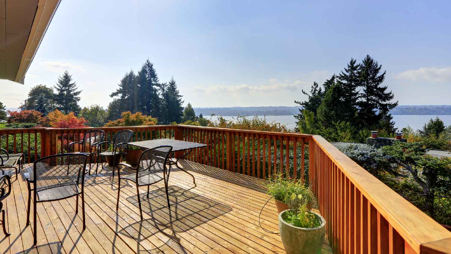 A wooden deck overlooking at nature and a lake 