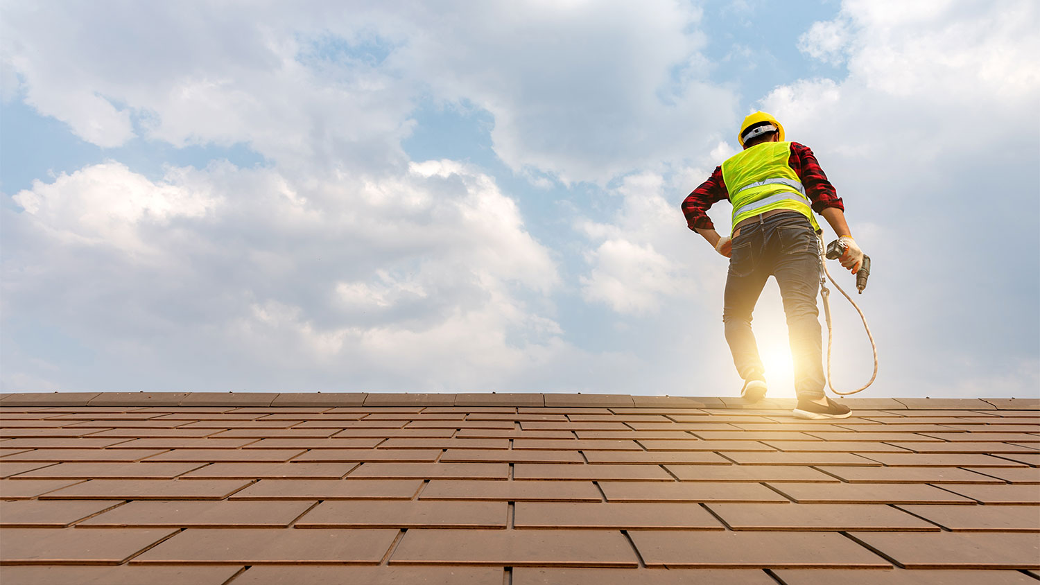 A worker stands on a roof